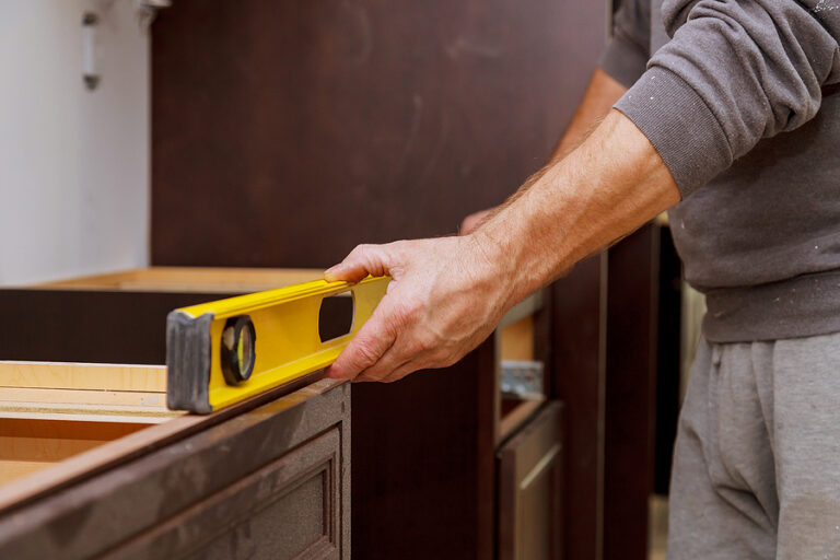 A man measuring level before installing a counter top.