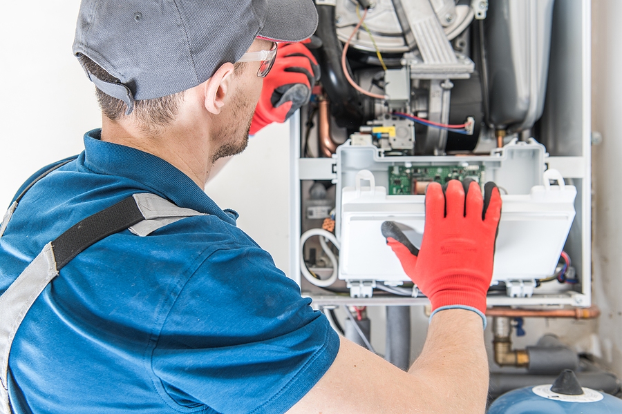 HVAC tech working on furnace.