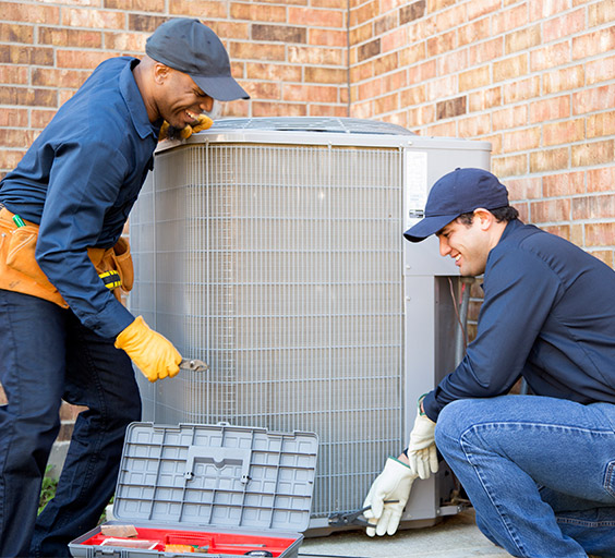 two men working on an AC unit